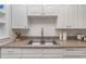 Close up of a kitchen sink featuring a stainless steel faucet, laminate counters, and white cabinetry at 1125 Josephine St, Lakeland, FL 33815