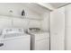 Efficient laundry room with a washer, dryer, shelving, and storage space at 1125 Josephine St, Lakeland, FL 33815