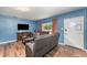 Bright living room boasts wood floors, comfortable seating, and large TV at 1125 Josephine St, Lakeland, FL 33815