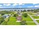Aerial view featuring the house, manicured lawn, and proximity to a tranquil lake in the background at 118 Caloosa Dr, Babson Park, FL 33827