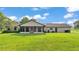 Beautiful backyard featuring manicured lawn and an enclosed patio, with an exterior view of the home at 118 Caloosa Dr, Babson Park, FL 33827