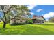 Lush backyard and manicured landscape with an exterior view of the home and enclosed patio at 118 Caloosa Dr, Babson Park, FL 33827