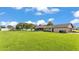 Expansive backyard featuring lush green lawn, shed, mature trees, and exterior view of the home at 118 Caloosa Dr, Babson Park, FL 33827