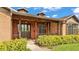 Inviting front porch with wood accents, brick siding, and manicured shrubbery at 118 Caloosa Dr, Babson Park, FL 33827
