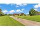 Long driveway leading to a well-maintained home with lush green front lawn and mature landscaping at 118 Caloosa Dr, Babson Park, FL 33827