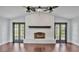 Spacious living room with traditional brick fireplace and hardwood flooring at 118 Caloosa Dr, Babson Park, FL 33827