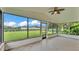Enclosed patio featuring tile floors, ceiling fan, and screened windows with views of the backyard at 118 Caloosa Dr, Babson Park, FL 33827