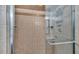 Tiled shower with glass door, shower caddy, and convenient grab bar at 118 Caloosa Dr, Babson Park, FL 33827