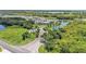 An aerial shot highlighting a water feature enhancing the entrance of a community with lush trees and landscaping at 122 St Thomas Dr, Mulberry, FL 33860