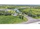 Community entrance with landscaped fountain, winding road, and nearby homes and a tranquil lake backdrop at 122 St Thomas Dr, Mulberry, FL 33860