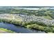Expansive aerial view of a lakeside community featuring modern homes, lush greenery, and tranquil waterscapes at 122 St Thomas Dr, Mulberry, FL 33860