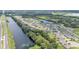 An elevated perspective showcasing a Primary-planned community nestled between a highway and a picturesque lake at 122 St Thomas Dr, Mulberry, FL 33860