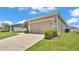 Beige single-car garage with concrete driveway and manicured lawn in front of a light-colored home at 122 St Thomas Dr, Mulberry, FL 33860