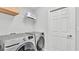 Bright laundry room with modern Samsung washer and dryer units, plus wire shelving above at 122 St Thomas Dr, Mulberry, FL 33860