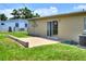 A view of the home's back exterior, including a sliding glass door to the backyard and a small patio area at 124 Carolyn Dr, Lakeland, FL 33803