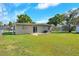 The house has a small patio, sliding doors, and a fenced yard with a lawn at 124 Carolyn Dr, Lakeland, FL 33803