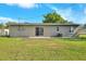 The back exterior features a sliding glass door, a small patio, an AC unit, and a well-maintained lawn at 124 Carolyn Dr, Lakeland, FL 33803