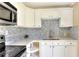 Updated kitchen features white cabinets, stylish backsplash, and modern appliances at 124 Carolyn Dr, Lakeland, FL 33803