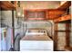 This is an interior shot of the laundry area with a washer, wood shelving, concrete block walls, and various utility connections at 124 Carolyn Dr, Lakeland, FL 33803