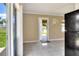 Living room with neutral paint and tile flooring visible from kitchen and backyard views at 124 Carolyn Dr, Lakeland, FL 33803