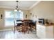 A sunlit breakfast nook with white cabinets, a wooden table, and built in black vinyl seating at 1300 Ariana Woods Cir, Auburndale, FL 33823
