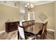 A dining room with a dark wood table, six chairs, and a decorative chandelier create a warm ambiance at 1300 Ariana Woods Cir, Auburndale, FL 33823