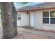 Exterior of house with white door, two windows, and landscape at 1300 Ariana Woods Cir, Auburndale, FL 33823