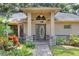 Inviting front entrance with a decorative door, stone accents, and lush landscaping at 1300 Ariana Woods Cir, Auburndale, FL 33823