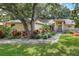 Charming single-story home with a beautifully landscaped front yard, mature trees, and inviting walkway at 1300 Ariana Woods Cir, Auburndale, FL 33823