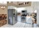 Bright kitchen featuring white cabinets, stainless steel appliances, and a mosaic tile backsplash at 1300 Ariana Woods Cir, Auburndale, FL 33823