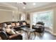 Comfortable living room features a leather sectional sofa, a large window, and modern decor at 1300 Ariana Woods Cir, Auburndale, FL 33823