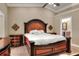 Warm main bedroom with a decorative bed frame, ceiling fan and views of the attached bathroom at 1300 Ariana Woods Cir, Auburndale, FL 33823