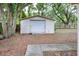 Detached storage shed with a roll-up door and concrete sidewalk at 1300 Ariana Woods Cir, Auburndale, FL 33823