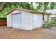 Detached storage shed featuring a roll-up door and side entrance at 1300 Ariana Woods Cir, Auburndale, FL 33823