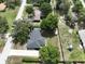 An aerial view shows the house and surrounding neighborhood with mature trees and landscaping at 1315 Costine Dr, Lakeland, FL 33809