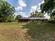 Back exterior of brick home with screened in porch overlooking the expansive lawn at 1315 Costine Dr, Lakeland, FL 33809