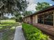 Charming brick home featuring manicured landscaping, a paved walkway and well maintained lawn at 1315 Costine Dr, Lakeland, FL 33809