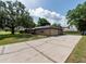 Brick home featuring a two-car garage and a long paved driveway at 1315 Costine Dr, Lakeland, FL 33809