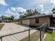 Brick house featuring an attached garage and long driveway surrounded by a well maintained yard at 1315 Costine Dr, Lakeland, FL 33809