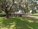 Inviting brick home with a well-maintained lawn and beautiful, mature tree providing ample shade at 1315 Costine Dr, Lakeland, FL 33809