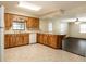 Bright kitchen features wood cabinets, stainless steel appliances, and an island that flows into the living area at 1315 Costine Dr, Lakeland, FL 33809