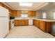 Kitchen featuring wood cabinets, white appliances, neutral countertops and flooring and lots of space at 1315 Costine Dr, Lakeland, FL 33809