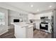 Bright, open kitchen boasts white cabinets, stainless appliances, and breakfast bar at 133 Cloverbrook Trl, Davenport, FL 33837