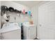Functional laundry room with washer, dryer, storage shelf, and ample space at 133 Cloverbrook Trl, Davenport, FL 33837