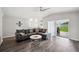 Open living space with gray sectional, ceiling fan, and sliding glass door to patio at 133 Cloverbrook Trl, Davenport, FL 33837