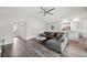 Cozy living room with gray sectional, ceiling fan, and wood-look floors at 133 Cloverbrook Trl, Davenport, FL 33837