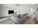 Bright living room featuring a gray sectional, TV, and open layout at 133 Cloverbrook Trl, Davenport, FL 33837