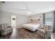 Bright bedroom with ceiling fan features two cozy patterned armchairs at 133 Cloverbrook Trl, Davenport, FL 33837