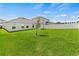 Expansive backyard with healthy green grass, white fence, and a young tree in the center at 1371 Madison Cir, Haines City, FL 33844