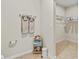 Neutral-toned bathroom with linen closet, towel rack, tile flooring and view to the walk-in closet at 1371 Madison Cir, Haines City, FL 33844